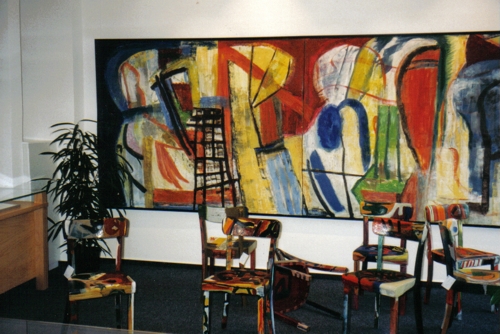 Ausstellung mit großformatiger Einrahmung und Installation mit bemalten Stühlen